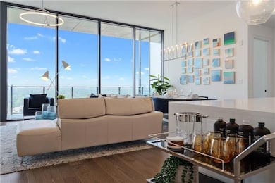 Dining area featuring wood finished floors, expansive windows, and a chandelier