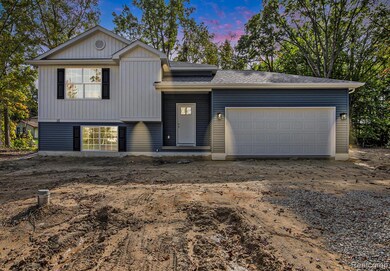 Split level home featuring driveway, an attached garage, board and batten siding, and roof with shingles