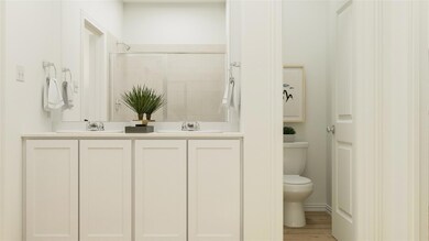 Bathroom with large vanity, toilet, hardwood / wood-style flooring, and dual sinks