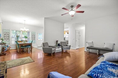 Living room with ceiling fan with notable chandeli