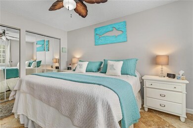 Bedroom with multiple closets, a textured ceiling, and ceiling fan