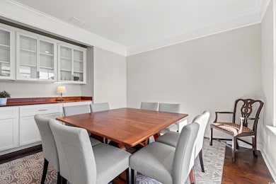 Dining room featuring crown molding and dark hardw