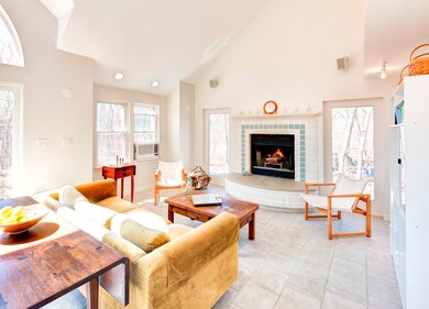 Great room with wood burning fireplace and soaring cathedral ceiling