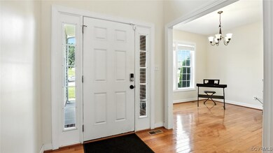 Foyer with a chandelier and wood finished floors