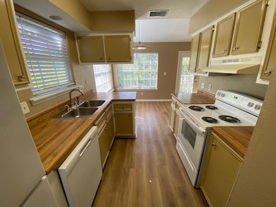 Kitchen featuring a sink, visible vents, wood fin