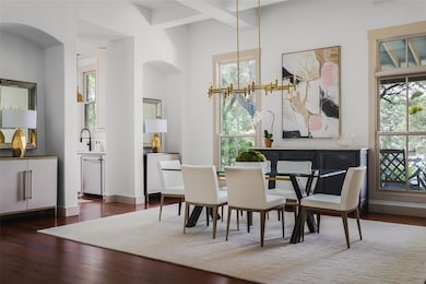 Dining room featuring arched walkways and hardwoo