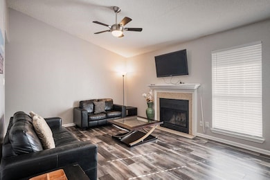 Living room with wood-type flooring, a textured ce