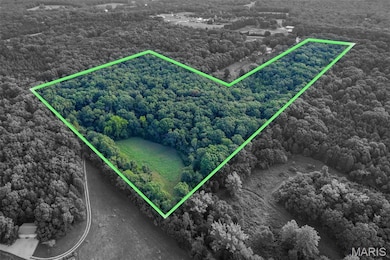 Aerial view of property's location with a heavily wooded area and property boundaries highlighted