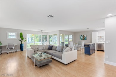 Living room featuring ceiling fan, light hardwood