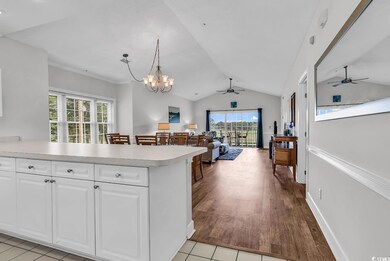 Kitchen featuring a ceiling fan, lofted ceiling, light countertops, open floor plan, and a peninsula