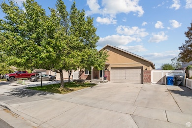 View of front of house featuring a gate, driveway, brick siding, stucco siding, and an attached garage