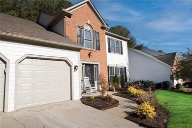 Traditional home with brick siding, a garage, a front lawn, and driveway