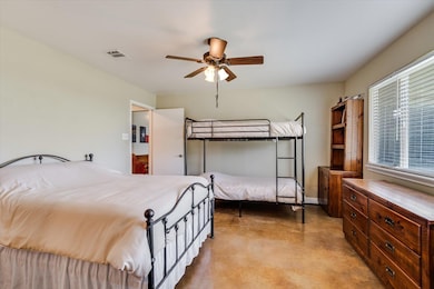 Bedroom with concrete floors and ceiling fan