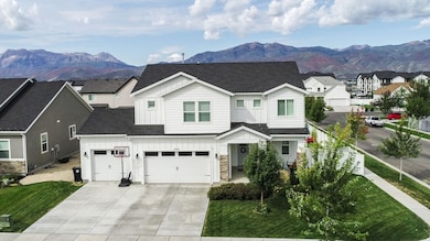 View of front facade with board and batten siding, roof with shingles, a mountain view, stone siding, and driveway
