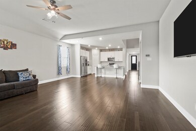 Living room with dark hardwood / wood-style flooring and ceiling fan