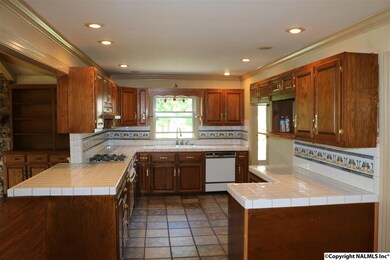 With recessed lighting, tile flooring and counter tops.  Appliances include cooktop, oven, dishwasher and disposal.