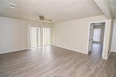 Empty room featuring hardwood / wood-style flooring, ceiling fan, and a textured ceiling