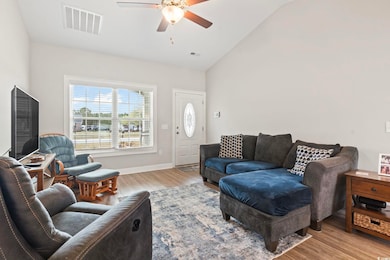 Living room featuring visible vents, high vaulted 