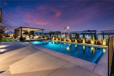 Pool at dusk featuring fence, a patio area, ceilin