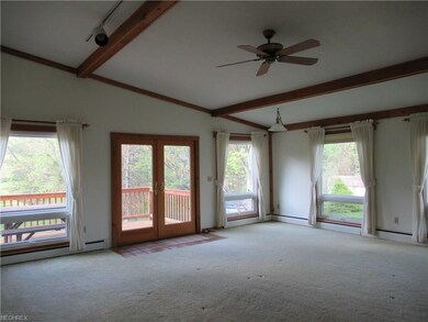 Vaulted, beamed ceiling in spacious Living Room. French doors to deck.