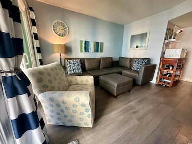 Living room with wood finished floors and a textured ceiling