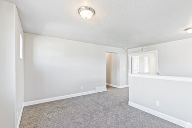 Unfurnished room with light carpet and a textured ceiling