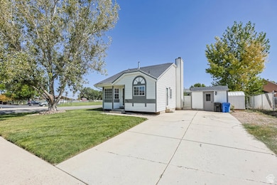 Bungalow-style house with an outdoor structure, a chimney, and driveway