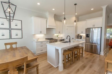Kitchen featuring stainless steel fridge with ice dispenser, custom range hood, white cabinets, tasteful backsplash, and crown molding