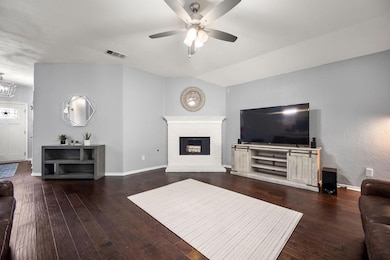 Living room featuring ceiling fan, a fireplace, an