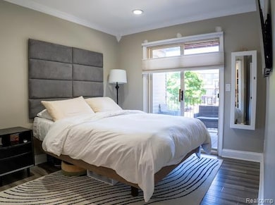 Bedroom with crown molding, wood finished floors, access to outside, and recessed lighting