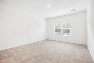Spare room featuring light carpet, visible vents,
