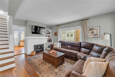 Living room with built in features, a fireplace, and dark hardwood / wood-style floors