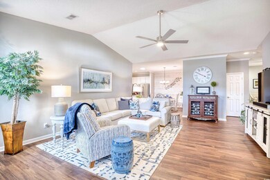 Living room with ceiling fan with notable chandeli