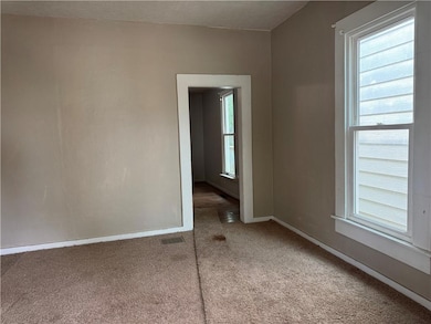 Living room with light colored carpet and a textured ceiling
