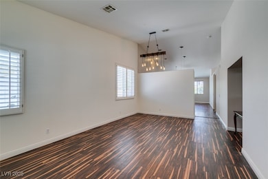 Empty room featuring dark wood-style flooring, a t