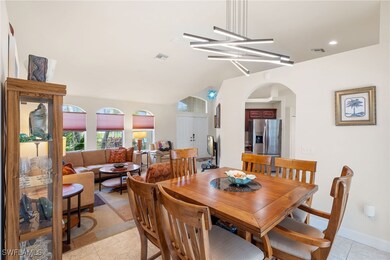 Tiled dining room featuring vaulted ceiling and a