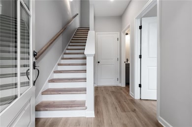 Stairs with wood finished floors and baseboards