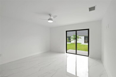 Spare room with light marble finish floors and a ceiling fan