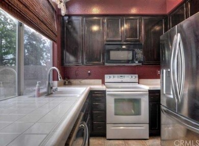 Kitchen features stainless steel appliances, dark 