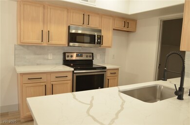 Kitchen with light brown cabinets, a sink, and sta