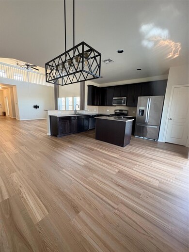 Kitchen with fridge, a sink, dark cabinets, a tow