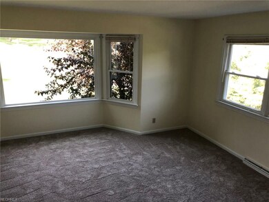The newly carpeted living room has a bay window an