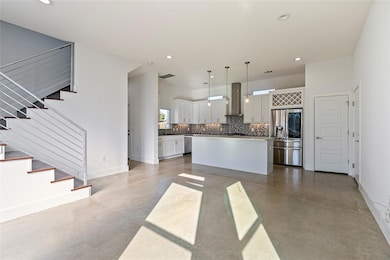 Kitchen with concrete floors, pendant lighting, backsplash, appliances with stainless steel finishes, and recessed lighting