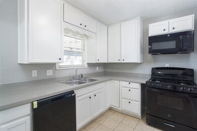 Quartz countertops and black appliances in this ch