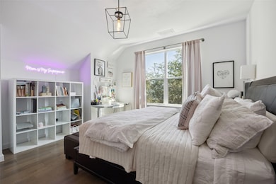 Bedroom featuring dark wood-style flooring and vaulted ceiling
