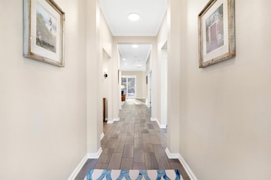 Hallway with baseboards and wood finish floors