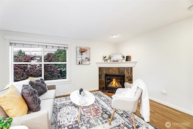 Living room with wood floors, corner fireplace, and great natural light