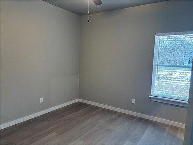Unfurnished room with dark wood finished floors, a ceiling fan, and baseboards
