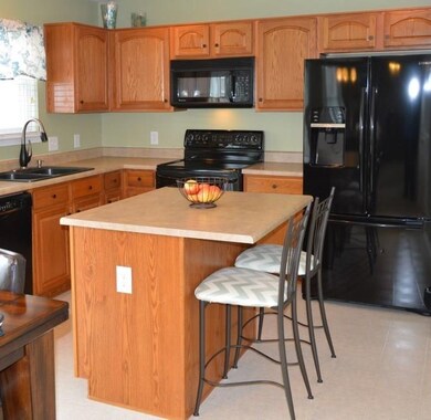 Kitchen with center island and newer Bosch dishwasher and French-door refrigerator.