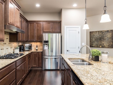 Kitchen with stainless steel fridge, gas cooktop,